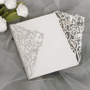 Détails de motifs floraux découpés au laser et paillettes argentées sur invitation de mariage