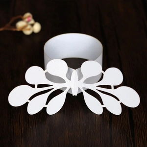 Macro detail of laser-cut white butterfly napkin ring made of pearl paper on wood