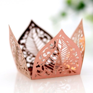 Macro view of rose gold laser-cut leaf pattern on wedding candy box favors