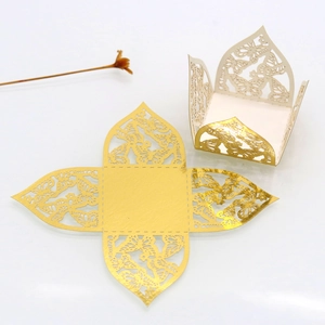 Detail der lasergeschnittenen Schmetterlingsmuster auf goldenem Geschenkkarton aus Papier