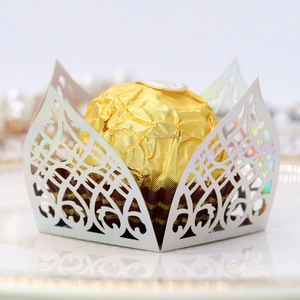 Macro shot of white laser-cut hollow pattern chocolate paper tray with iridescent coating
