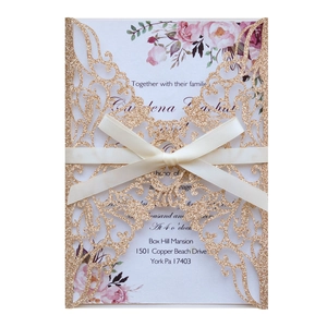 Détail de l'invitation de mariage dorée à découpe laser avec insert fleuri et ruban