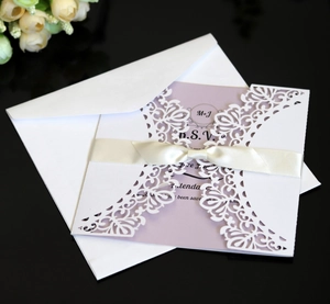 Detailed laser-cut wedding invitation with white lace shell and purple inner card