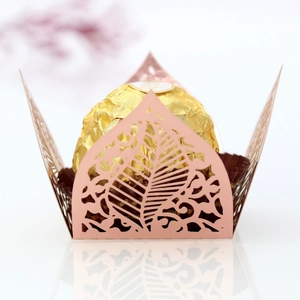 Close-up of laser-cut rose gold paper favor box with intricate hollow leaf patterns