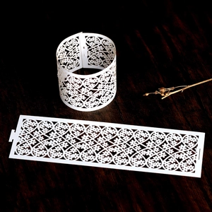 Close-up of white laser-cut napkin ring with floral heart lace design on dark wood table