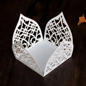 Macro view of white laser-cut hollow lace candy box with intricate floral patterns