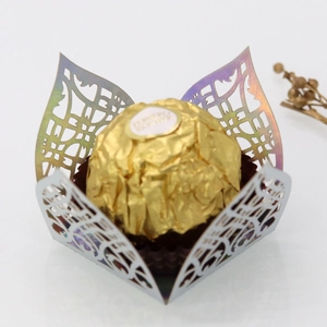 Macro shot of laser-cut gold pearlescent paper wrapper with intricate vine patterns