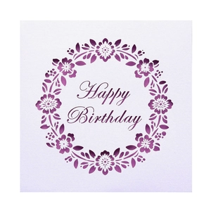 Detail of laser-cut purple floral wreath and Happy Birthday text on white paper card