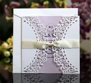 Detailed laser cut wedding invitation with lavender card and cream silk ribbon bow