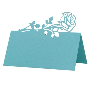 Macro detail of laser-cut lake blue rose table card with pearl paper texture