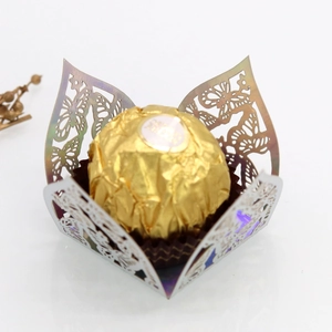 Macro view of laser-cut butterfly chocolate wrapper with iridescent hollow floral pattern