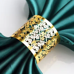 Close-up of golden hollow clover napkin ring with intricate floral laser cut patterns
