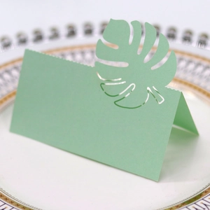 Détail d'un marque-place feuille de monstera découpée au laser sur une assiette