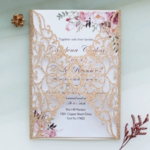 Détail du faire-part de mariage doré à paillettes découpé au laser avec insert floral