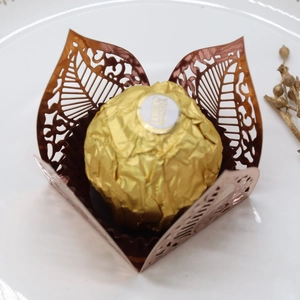 Macro detail of laser-cut purple hollow leaf chocolate wrapper for wedding party favors