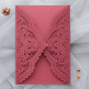 Close-up of laser cut floral lace hollow design on burgundy wedding invitation cover