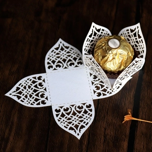 Laser-cut white floral candy box detail with intricate paper patterns and chocolate use