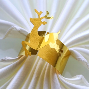 Macro detail of golden reindeer mirror-finish paper napkin ring on a white cloth