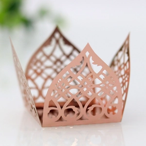 Macro detail of rose gold laser cut cupcake wrappers with ornate hollow floral pattern
