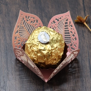 Detail of pink laser-cut hollow leaf paper candy box with gold chocolate inside