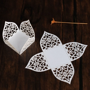 Detailed laser-cut white paper box with intricate hollow patterns for wedding sweets