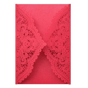 Macro detail of red laser-cut lace wedding invitation cover with pearlescent finish