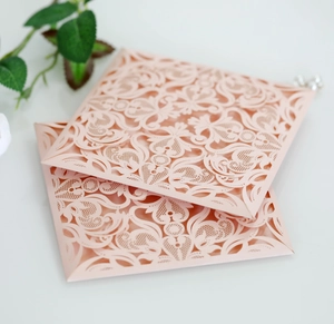 Detailed laser-cut pink lace floral wedding invitation cards with premium pearlescent texture