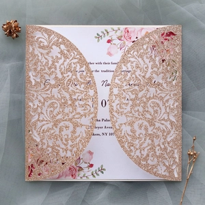 Détail du faire-part de mariage ajouré en or rose pailleté avec décor floral