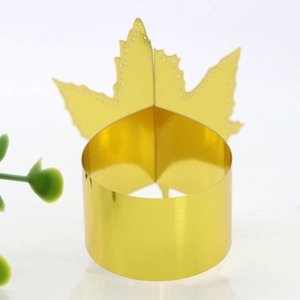 Close-up of golden maple leaf paper napkin ring with intricate hollow dot patterns