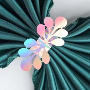 Macro detail of iridescent laser cut napkin rings with elegant floral leaf patterns