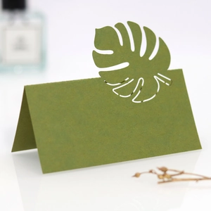 Détail de la feuille de monstera découpée au laser sur un marque-place vert foncé