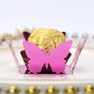 Macro detail of pink 3D butterfly candy box base holding a golden foil chocolate