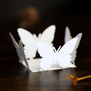 Macro detail of laser-cut white butterfly paper candy box with intricate lace hollow design