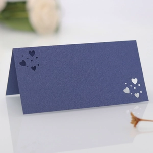 Detalle de tarjeta de mesa azul marino con corazones troquelados con láser fino