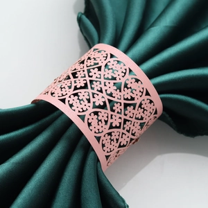 Close-up of pink pearlescent paper napkin ring with laser-cut floral hollow patterns