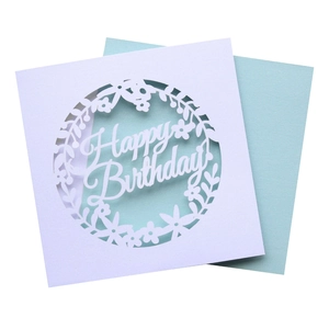 Detail of laser cut Happy Birthday card with floral wreath design and blue insert