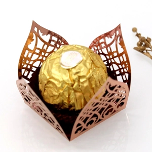 Macro shot of laser-cut gold lace hollow flower chocolate wrapper for wedding favors