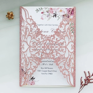 Détail macro de l'invitation de mariage découpée au laser avec décor floral