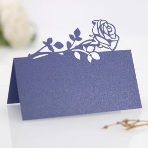 Detailed laser-cut navy blue place card with intricate rose pattern for wedding tables