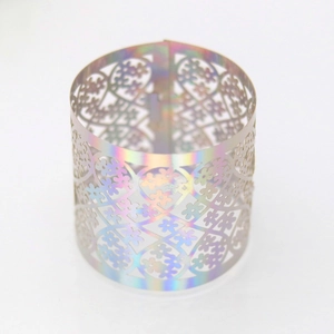 Detailed macro of laser-cut floral pattern on iridescent golden napkin ring holder