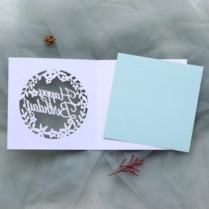 Close-up of laser-cut floral wreath and Happy Birthday text on premium paper card