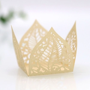 Detail of laser-cut crown leaf pattern on champagne gold paper candy box for party decor
