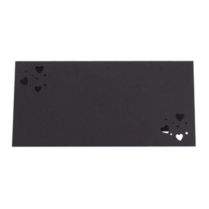 Detalle de la tarjeta de lugar de boda negro mate con delicado recorte de corazón