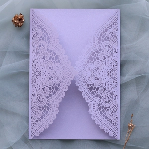 Close-up of laser cut lace lavender wedding invitation cover with shimmering paper texture