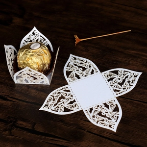 Detailliertes lasergeschnittenes Schmetterlingsmuster auf weißen Pralinen-Papierhüllen
