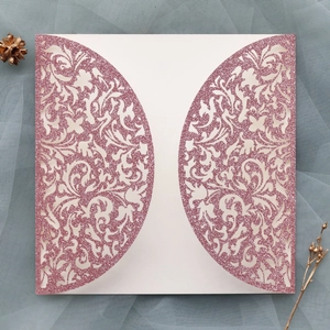 Gros plan des motifs floraux découpés au laser sur une carte d'invitation rose pailletée