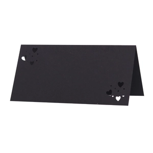 Detalle de tarjetas de mesa negras con corazón calado con láser para bodas elegantes
