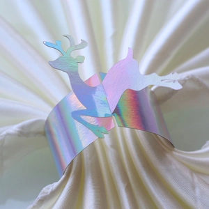 Detailed macro of iridescent laser-cut reindeer paper napkin rings with rainbow reflection