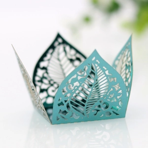 Macro shot of tiffany blue laser-cut leaf pattern cupcake wrapper with mirror reflection