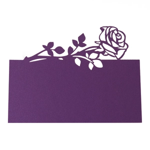 Detailed laser-cut rose design on deep purple cardstock for wedding place cards